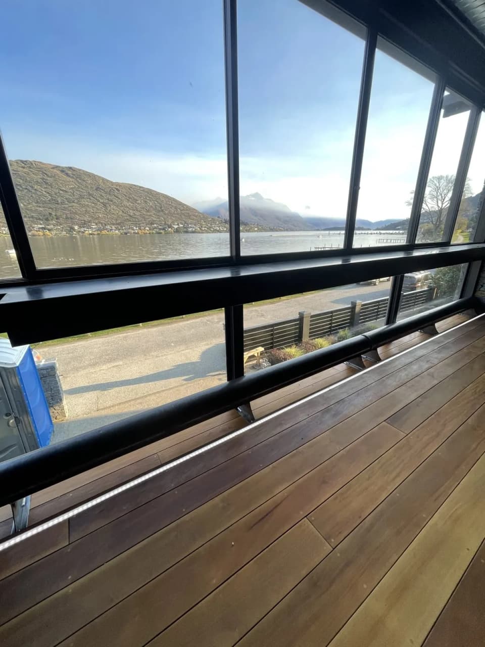 Black steel balustrade along a deck edge with a lake view beyond