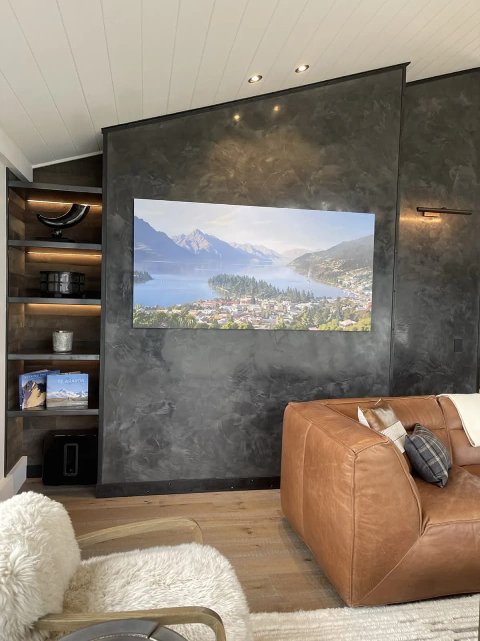 Blackened steel feature wall with a TV and built-in steel shelving