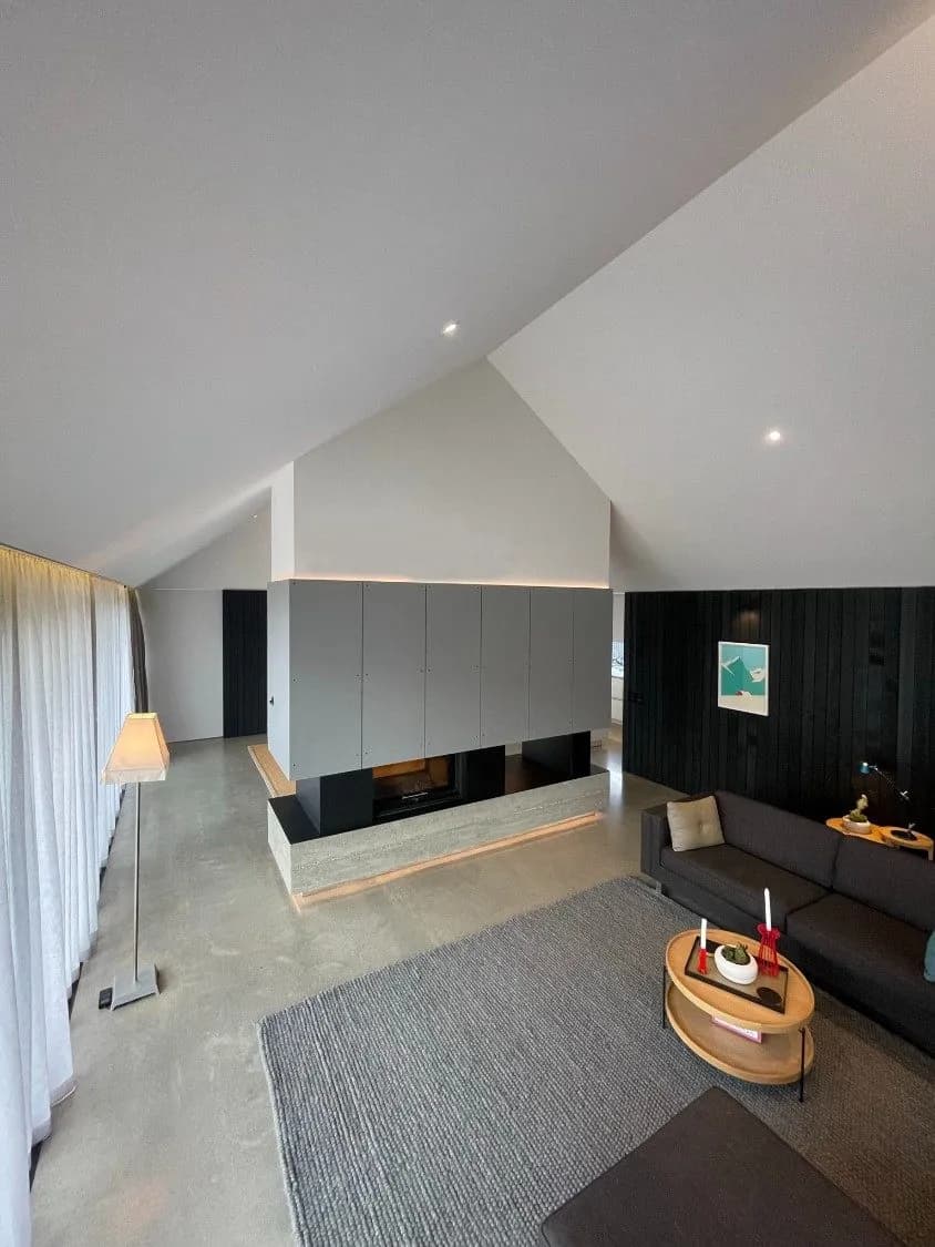 Panel-clad steel fireplace and chimney in a vaulted living room, Queenstown